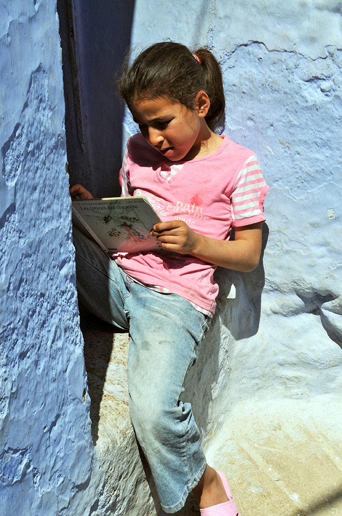 Rapariga a ler nas ruas de Chefchaouan