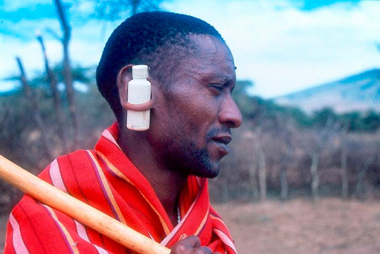 Guerreiro Masai vestido de vermelho com frasco a atravessar a orelha.