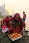 Mulher no rio Yamuna com Taj Mahal no fundo