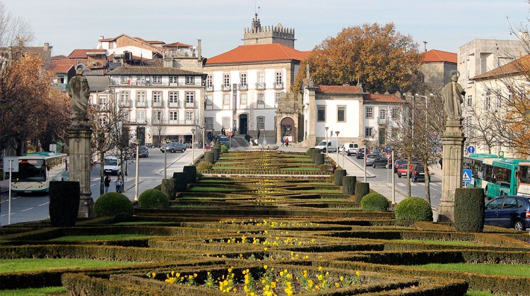 Avenida no centro histórico de Guimarães, com castelo ao fundo.