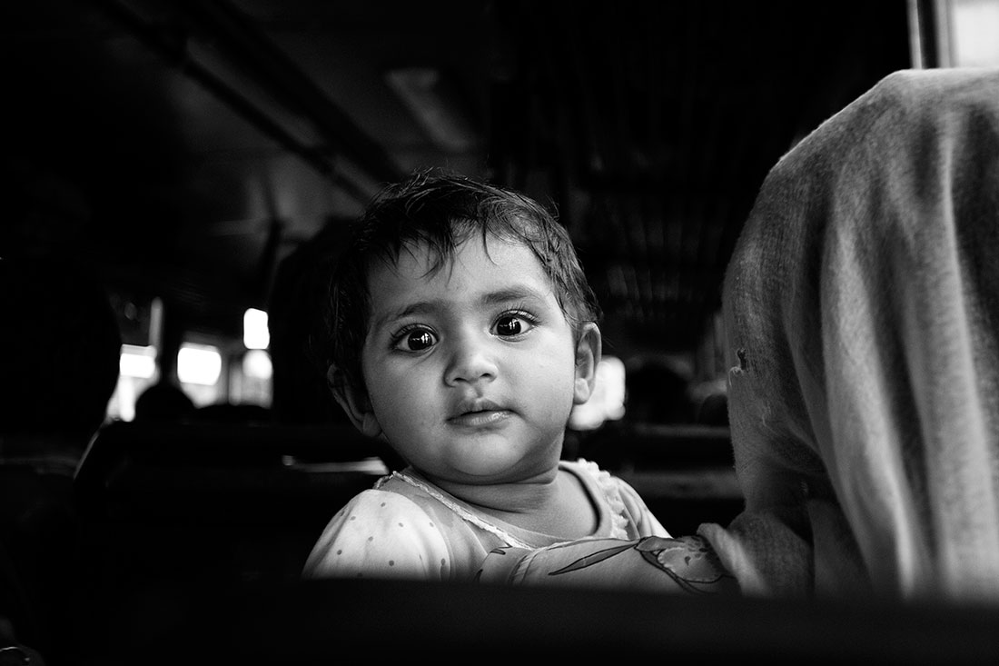 criança ao colo em comboio na Índia