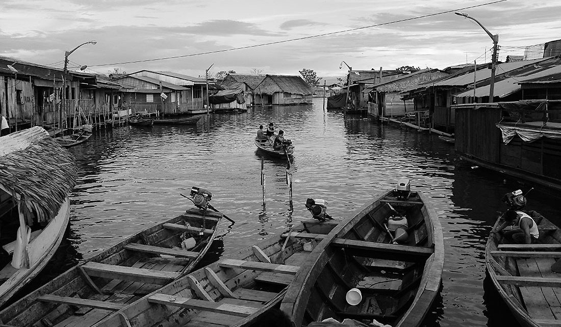 canal com canoas e várias casas de madeira em Iquitos