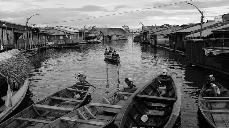 canal com canoas e várias casas de madeira em Iquitos