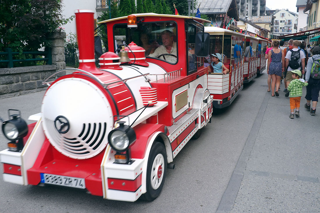 comboio vermelho e branco transporta turistas no centro de chamonix