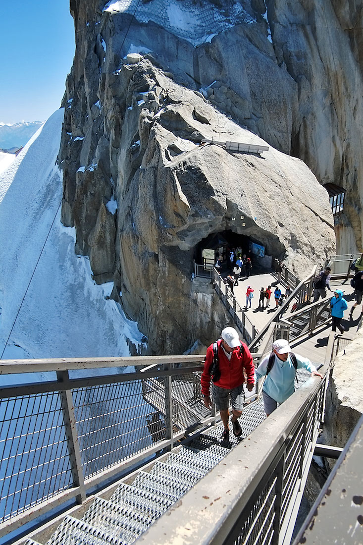 Turistas sobem escadas que levam ao complexo turístico instalado no topo da Aiguille du Midi