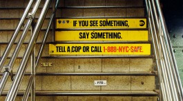 escadaria da estação de metro com inscrição “If you see something, say something”
