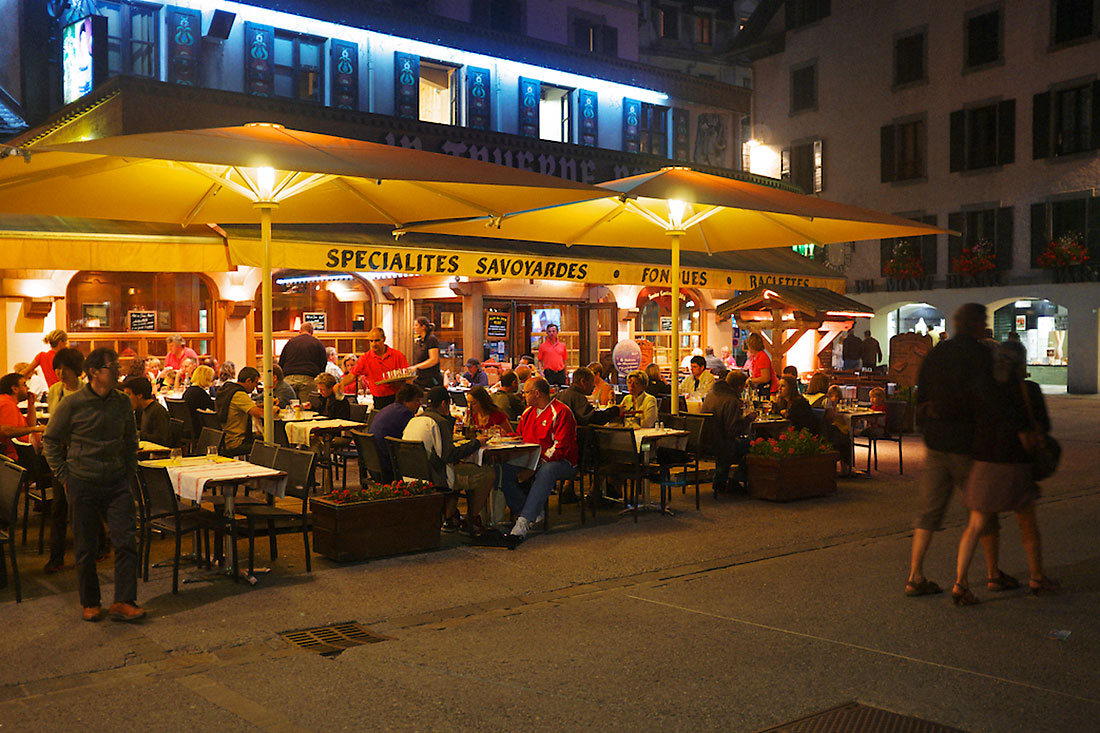 turistas e habitantes locais preparam-se para jantar numa esplanada de chamonix