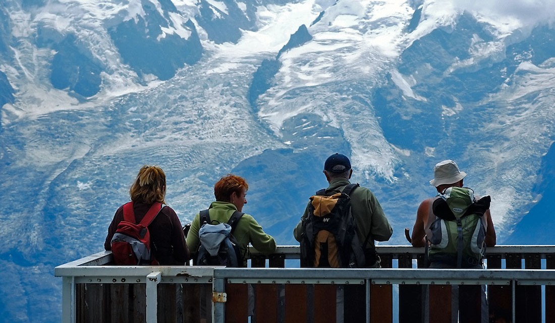turistas contemplam o maciço do Monte Branco a partir da face oposta do vale de Chamonix