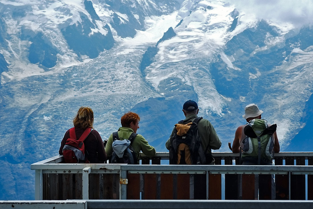 turistas contemplam o maciço do Monte Branco a partir da face oposta do vale de Chamonix