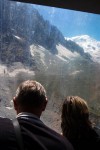 casal de turistas observa o maciço do Monte Branco do interior de uma cabine de teleférico