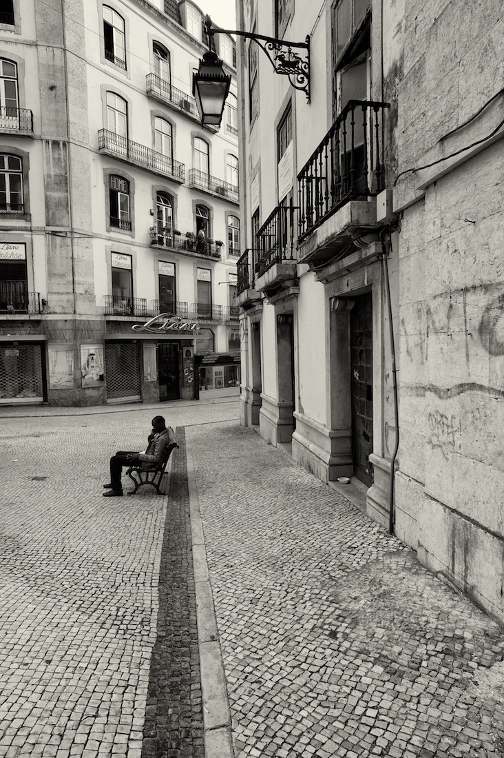 homem ao telemóvel em banco de jardim na baixa de Lisboa