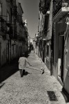 mulher passeia cao em rua estreita do bairro da madragoa