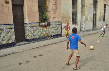 Meninos que jogam à bola numa rua de Centro Havana