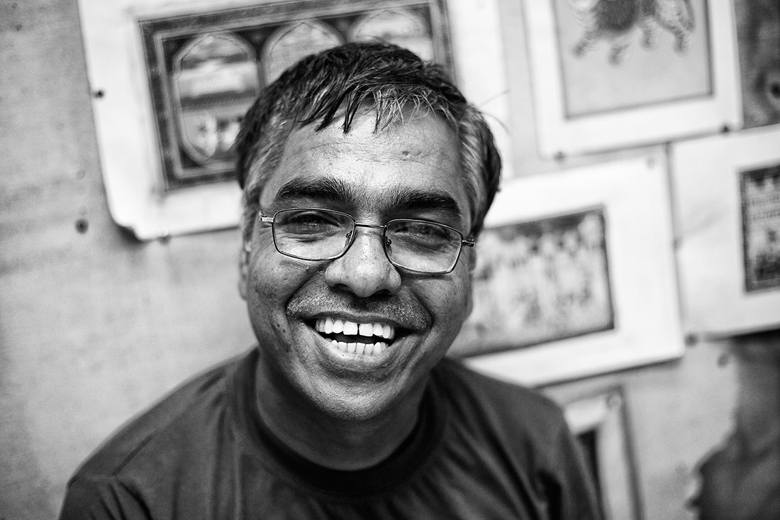 homem indiano com óculos e um grande sorriso