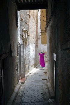 mulher que caminha numa rua estreita da medina de fez