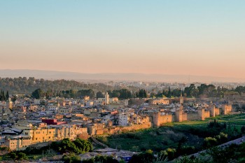 muralhas e medida da cidade de Fez, em Marrocos, iluminadas pela luz amarelada do pôr-do-sol