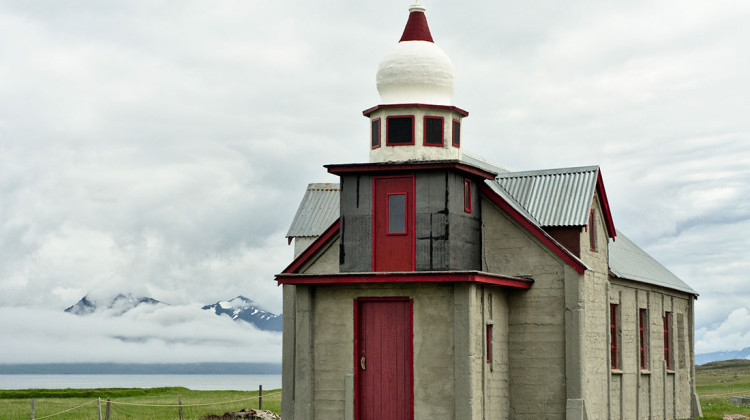 capela em betão com cúpula branca e pormenores vermelhos construída por Samúel Jónsson em Selardalur