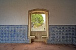 Sala decorada com azulejos com janela que dá para um jardim do Convento de Cristo