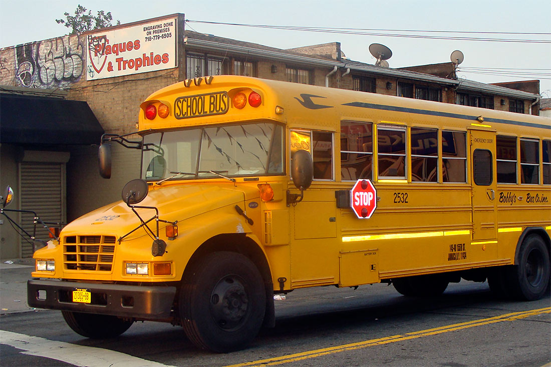 tipico autocarro escolar americano, em cor amarelo forte, junto à avenida 51 em Queens