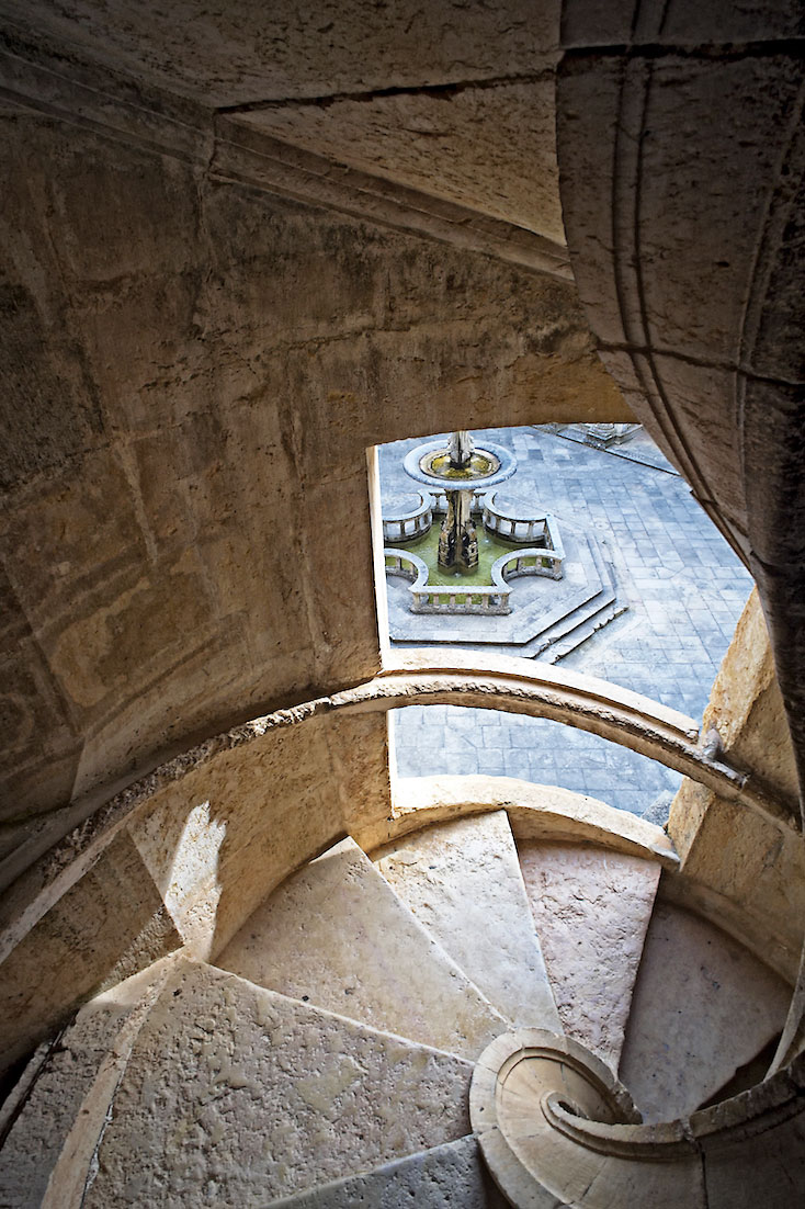 escada em caracol de onde se avista a fonte central do claustro principal do Convento de Cristo.