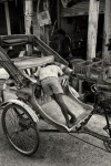 homem a dormir sobre o seu rickshaw