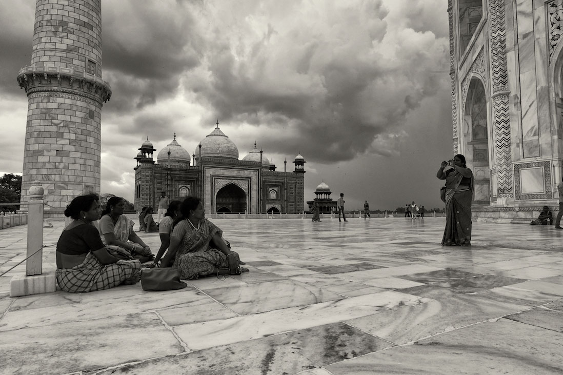 Grupo de mulheres indianas a fotografarem-se junto ao Taj Mahal.
