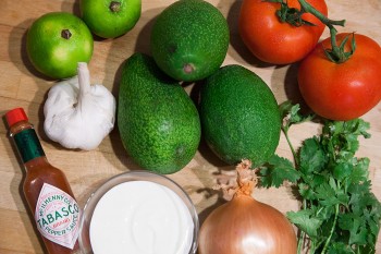 Abacate, cebola, tomate, alho, coentros, nata e tabasco utilizados na preparação do guacamole.