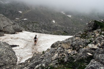 Montanhista a caminhar sobre o glaciar no parque nacional de Durmitor no Montenegro.