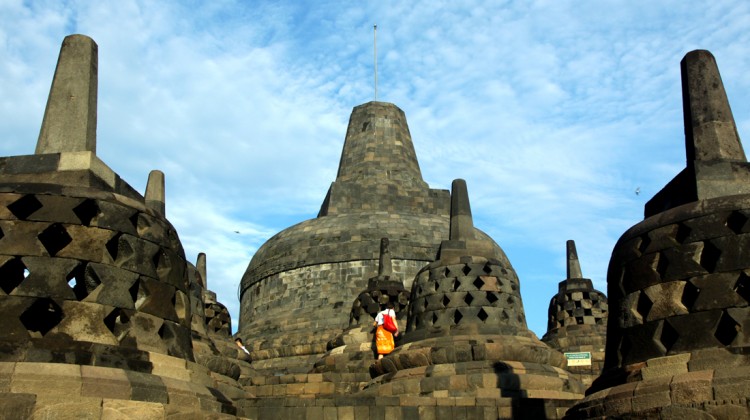 No topo do Templo de Borobudur um turista passeia no meio das estupas