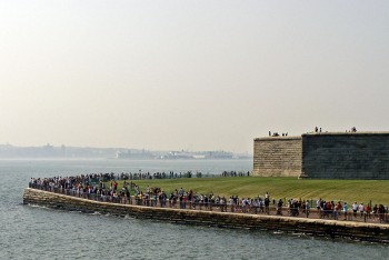 Muitas pessoas na extremidade da Liberty Island junto à base da estátua da liberdade.