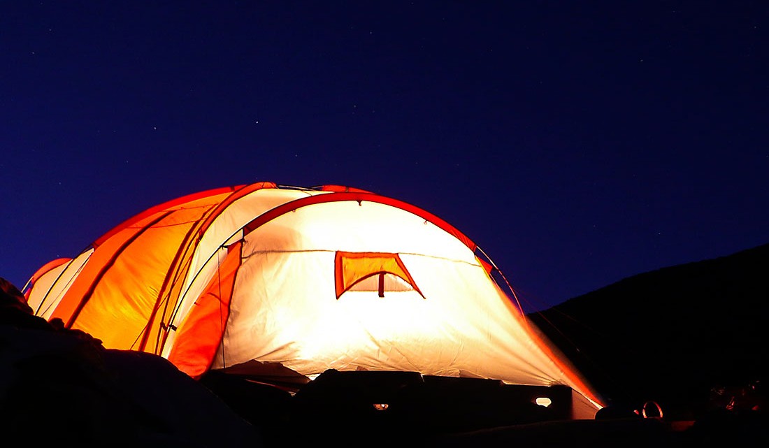 Interior de tenda iluminado durante a noite.
