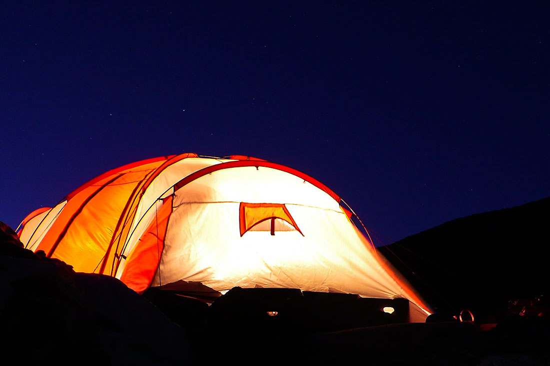Interior de tenda iluminado durante a noite.
