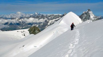 Alpinista isolado a caminhar sobre o tapete de neve existente na aresta do Breithorn