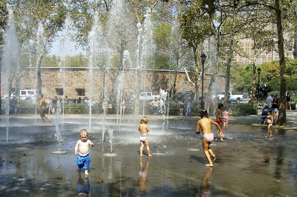 Crianças a brincar junto aos repuxos da fonte em Battery Park, Manhattan