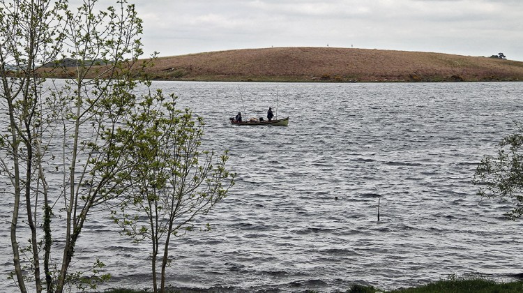 Barco com dois pescadores num lado do Parque Nacional de Conemara, na Irlanda.