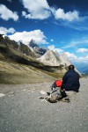 Montanhista sentado num col aprecia a paisagem na região do Monte Branco.