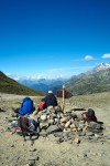 Montanhista sentado numa mariola junto a placa identificadores observa a paisagem natural do Monte Branco.