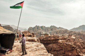 Bandeiras jordanas e tendas de chá com com vista para wadi araba perto do Mosteiro em Petra.