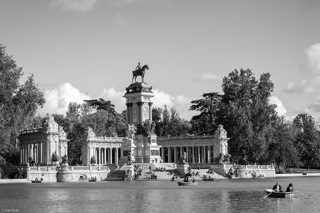 Barcos a remos junto a grande escultura no lago do Parque do Retiro em Madrid.