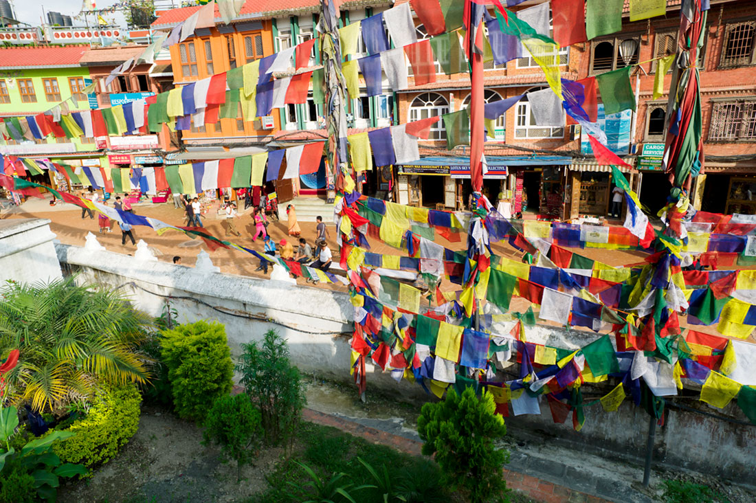 Bandeiras de oração budista esvoaçam por sobre as ruas da cidade de Kathmandu.