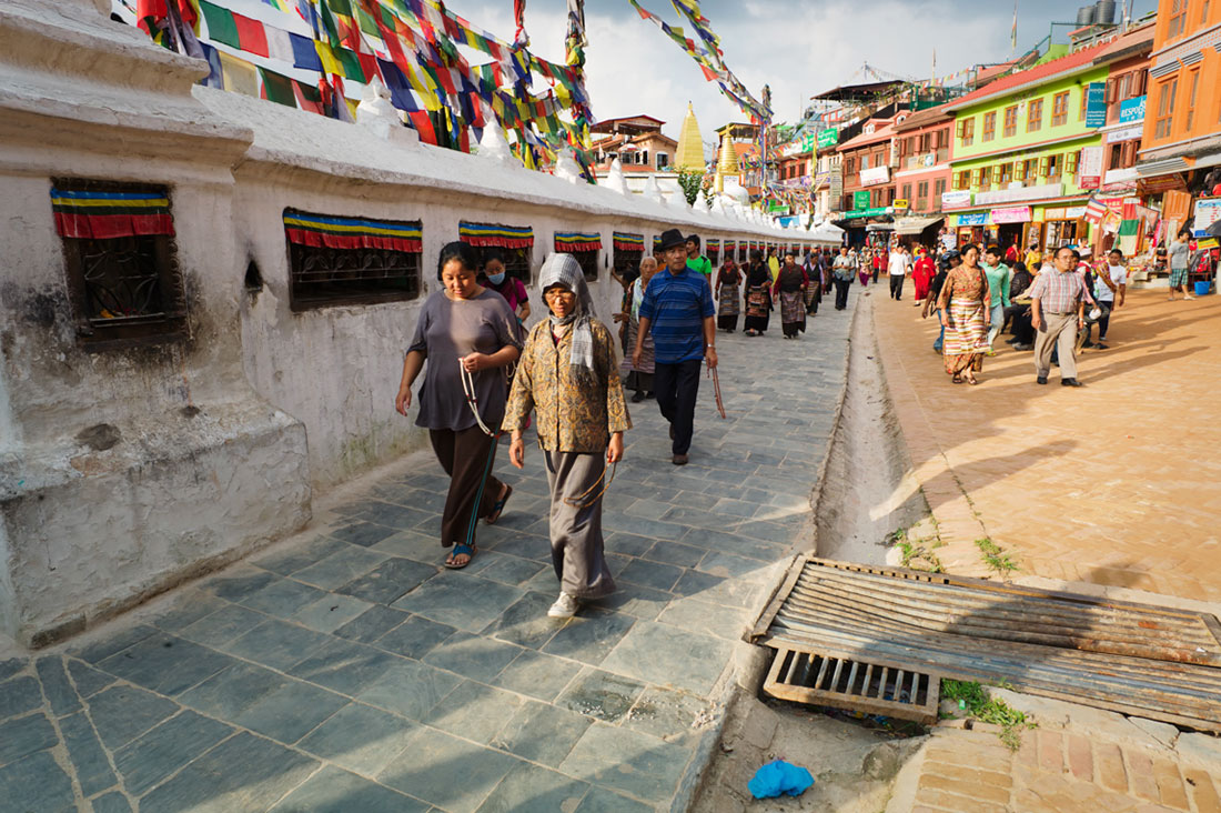 Pessoas caminham em oração ao redor da Boudhanath Stupa em Kathmandu.