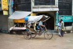 Homem pedala no seu riquexó numa rua antiga de Kathmandu.