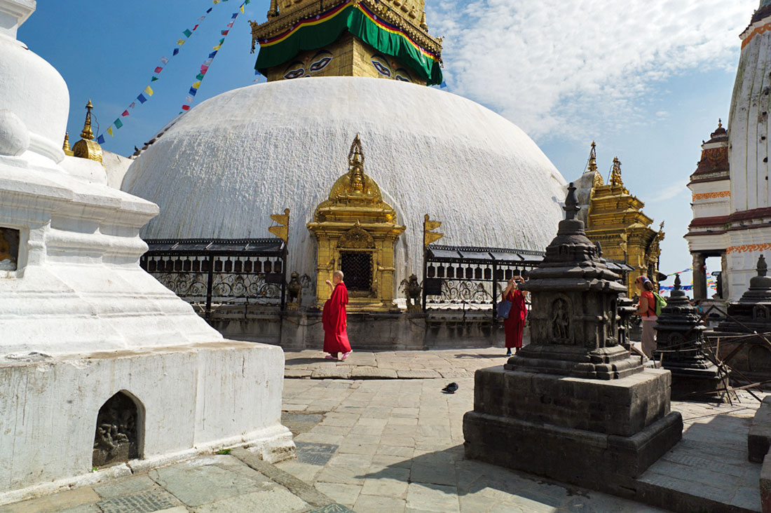 Monges budistas caminham em redor da Boudhanath Stupa em Kathmandu.