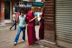 Monges budistas escrevem mensagens nos telemóveis numa esquina da cidade antiga de Kathmandu.