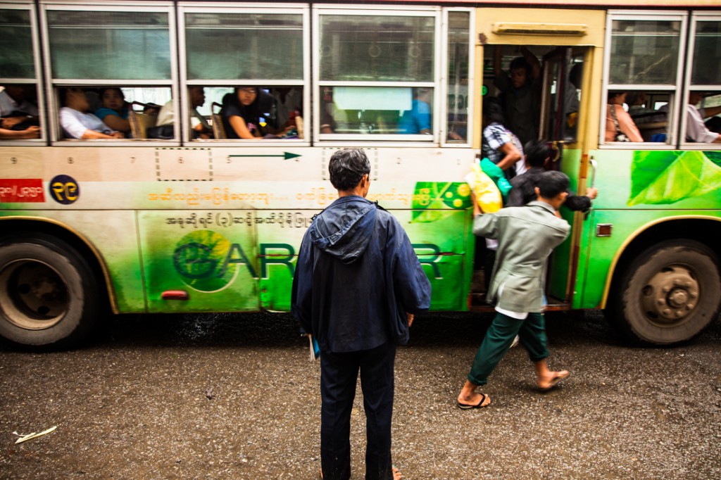 Ajudante e cobrador de autocarro em Yangon.