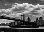 Ponte de Brooklyn, sobre o rio East e sob um céu carregado de nuvens.